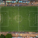 Futebol de várzea em 2025: 6 rituais e a paixão comunitária Campo de futebol de várzea vibrante com torcida em festa no Brasil em 2025.