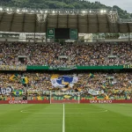 Estádio lotado durante um clássico de futebol brasileiro em 2025, com torcidas vibrantes e coloridas, simbolizando a intensidade das rivalidades.
