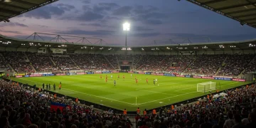Estádio de futebol lotado ao entardecer, simbolizando a recuperação e o sucesso de um clube após uma crise.