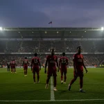 Jogadores caminhando em campo iluminado, simbolizando transferências de inverno no Brasileirão.