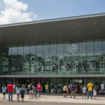 Fachada moderna do Museu do Futebol no Brasil, com visitantes de todas as idades entrando, refletindo a paixão nacional pelo esporte.