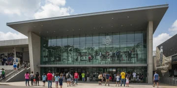 Fachada moderna do Museu do Futebol no Brasil, com visitantes de todas as idades entrando, refletindo a paixão nacional pelo esporte.