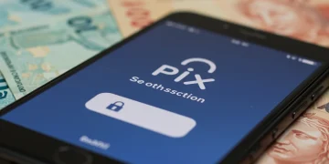 Smartphone com o logo do Pix e notificação de transação segura, com notas de real desfocadas ao fundo.