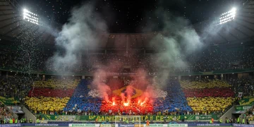 Torcida vibrante em estádio brasileiro com mosaico e bandeiras coloridas, celebrando a paixão pelo futebol em 2025.