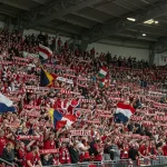 Torcida vibrante em estádio lotado, celebrando o futebol com paixão e energia contagiante.