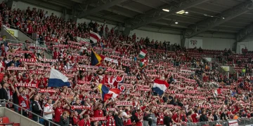 Torcida vibrante em estádio lotado, celebrando o futebol com paixão e energia contagiante.