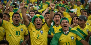 Copa 2026: Tradições e Superstições Brasileiras para o Hexa Torcedores brasileiros celebram com paixão, vestindo camisas amarelas e verdes, durante uma Copa do Mundo passada, simbolizando a magia e a tradição.
