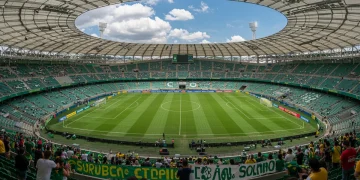 Estádio de futebol brasileiro com painéis solares e torcida engajada em sustentabilidade.