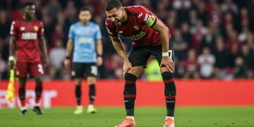 Jogador de futebol lesionado no campo, com semblante de dor, simbolizando o impacto das lesões chave.