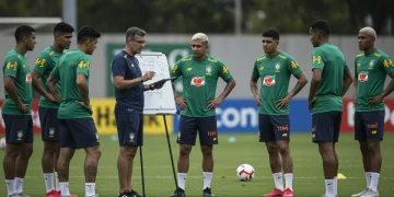 Psicólogo esportivo orientando jogadores de futebol em treino, focando na resiliência mental e coesão da equipe.